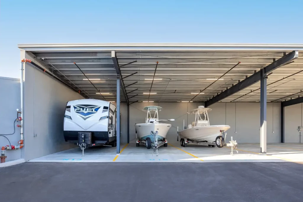 RV Camper and boats sits stored under covered units