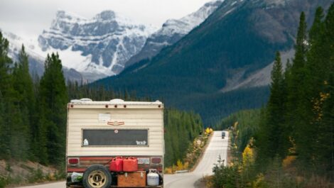 RV driving down the road towards the mountains.