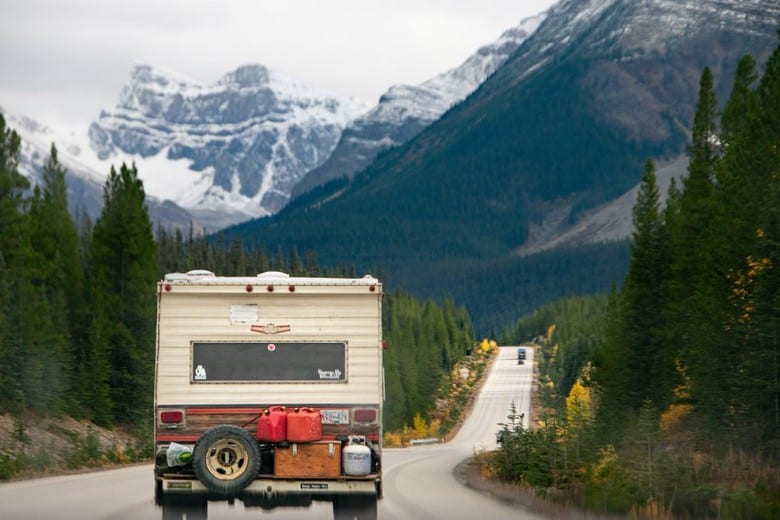 RV driving down the road towards the mountains.