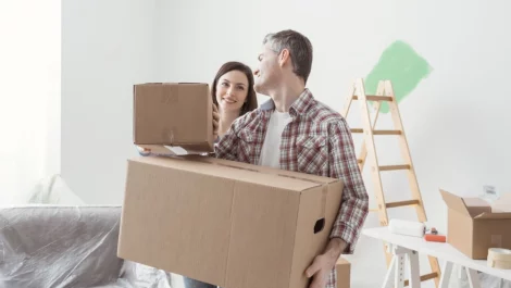 A couple moving boxes into their new home