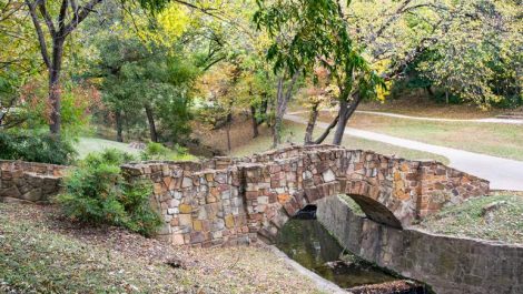 A bridge going over a small creek in the park