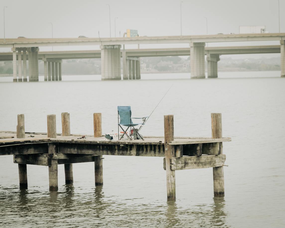 A chair and fishing pole on a dock at lake ray hubbard