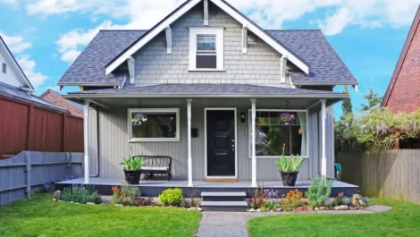 A cute, small home with a modest front porch and tasteful landscaping.