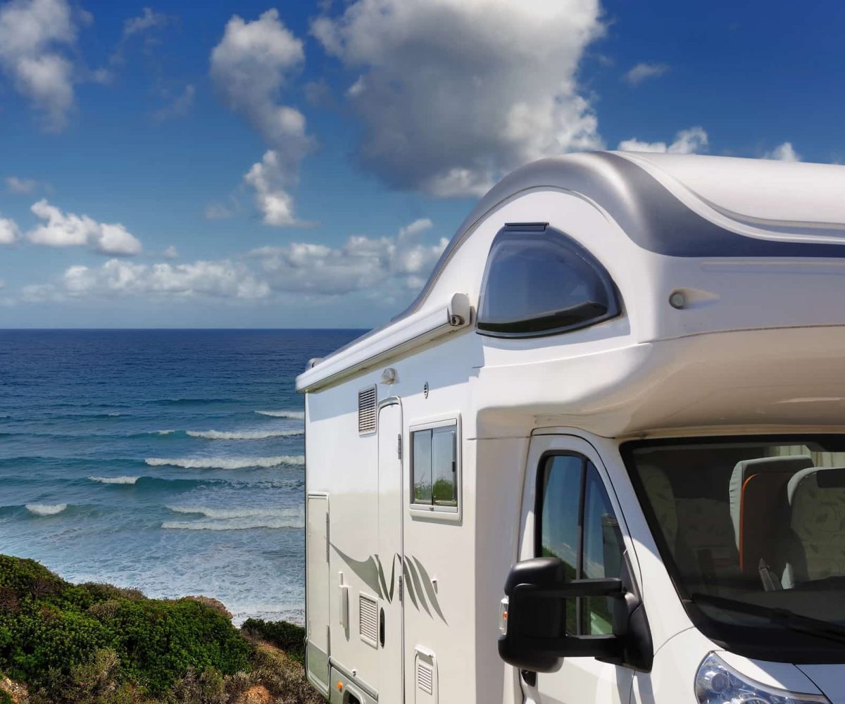 An RV parked beachside for a camping trip.