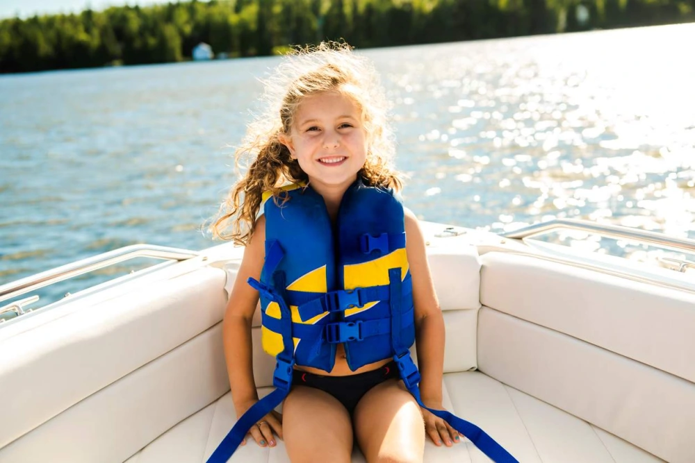 a young girl smiling and wearing her life jacket on the boat