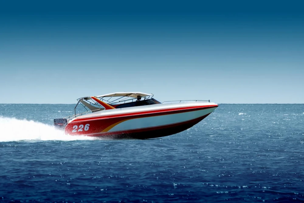 A red, white, and yellow speedboat cruising on the water