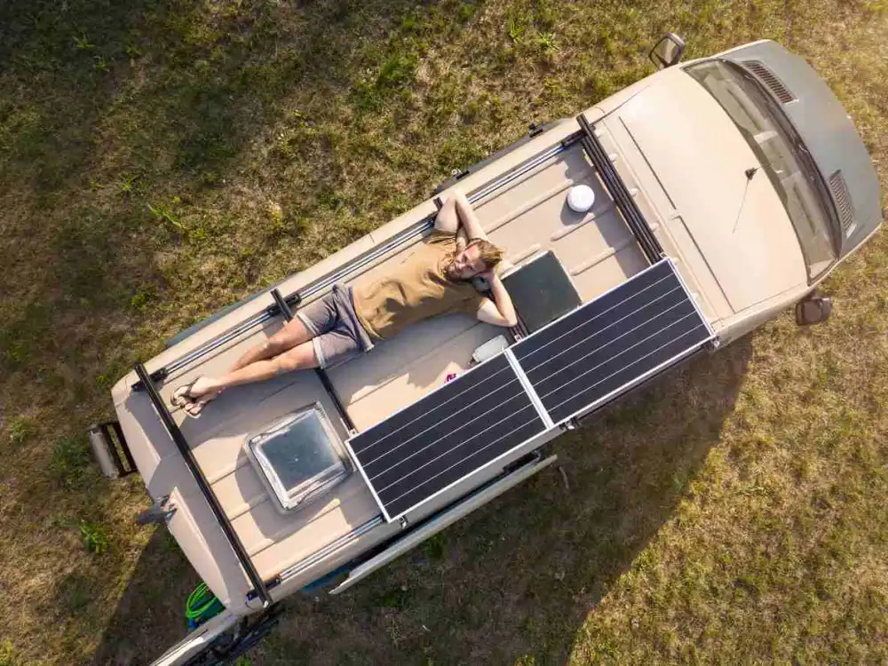 A man laying on top of his camper van roof