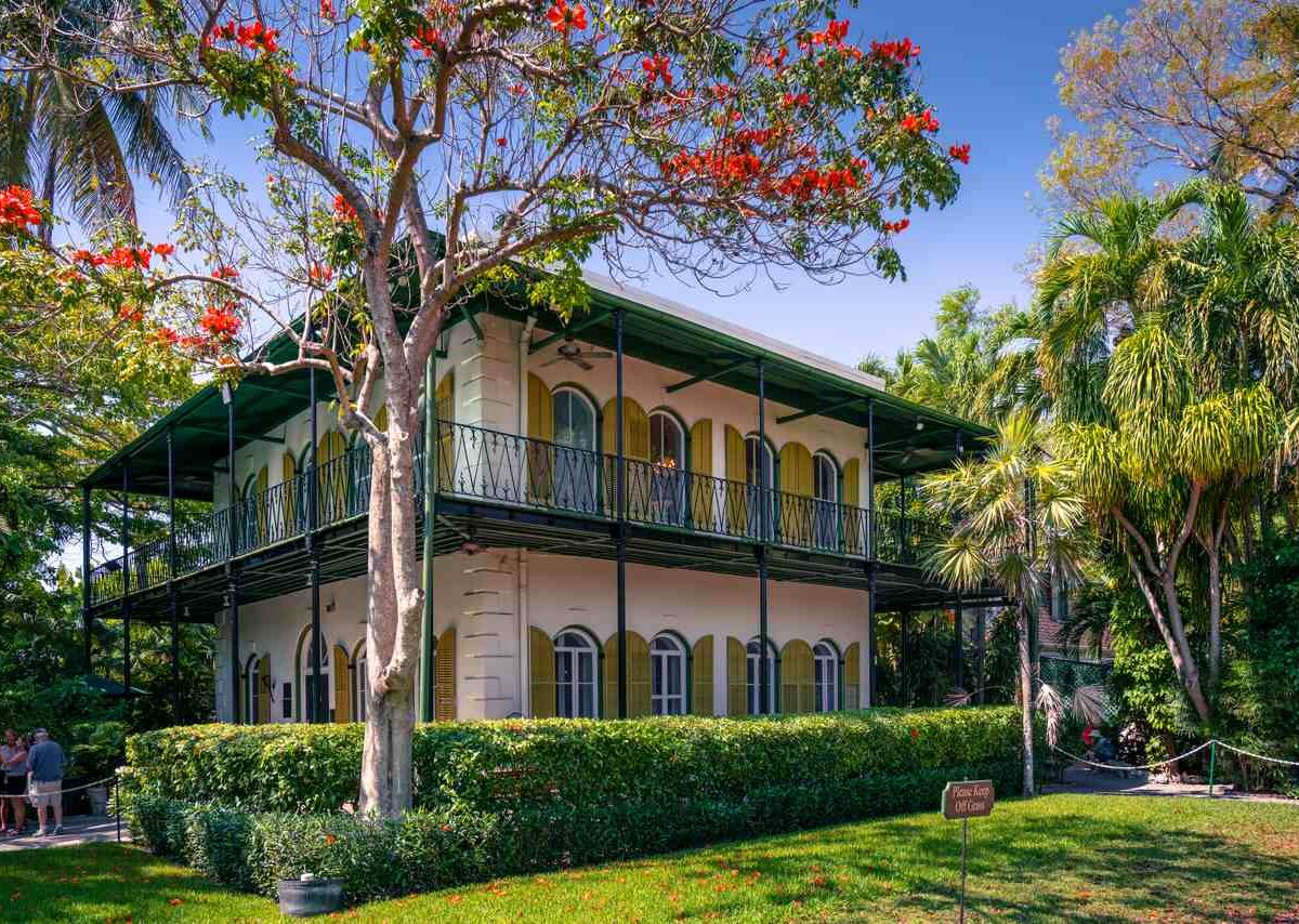 The Ernest Hemingway Home and Museum surrounded by trees in Key West, FL.